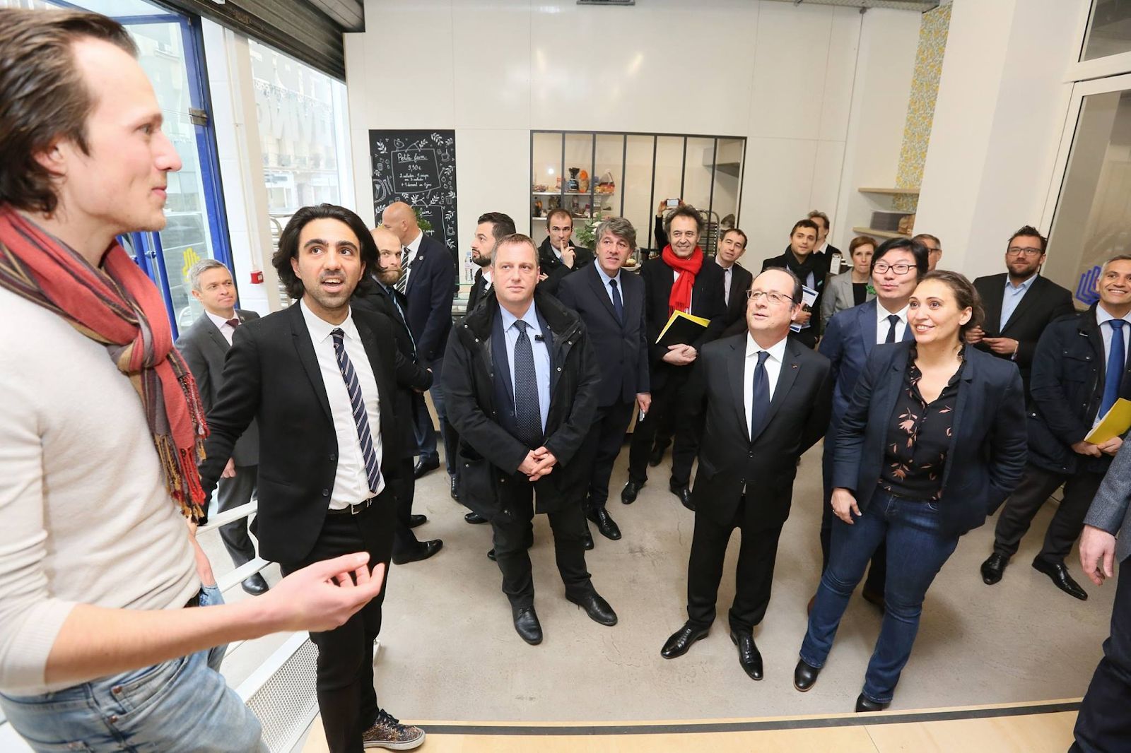 Gui speaking to President Hollande and his entourage in a lobby
