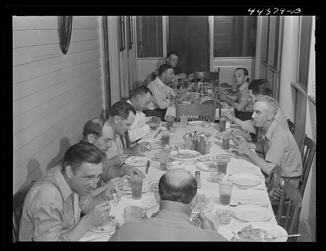 Workers from an Alabama munition plant eating dinner at their boarding house, 1941